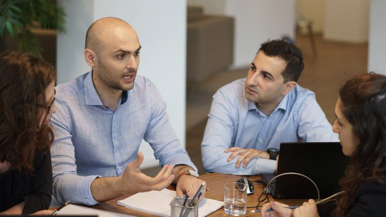 Image of some colleagues sitting at a table talking
