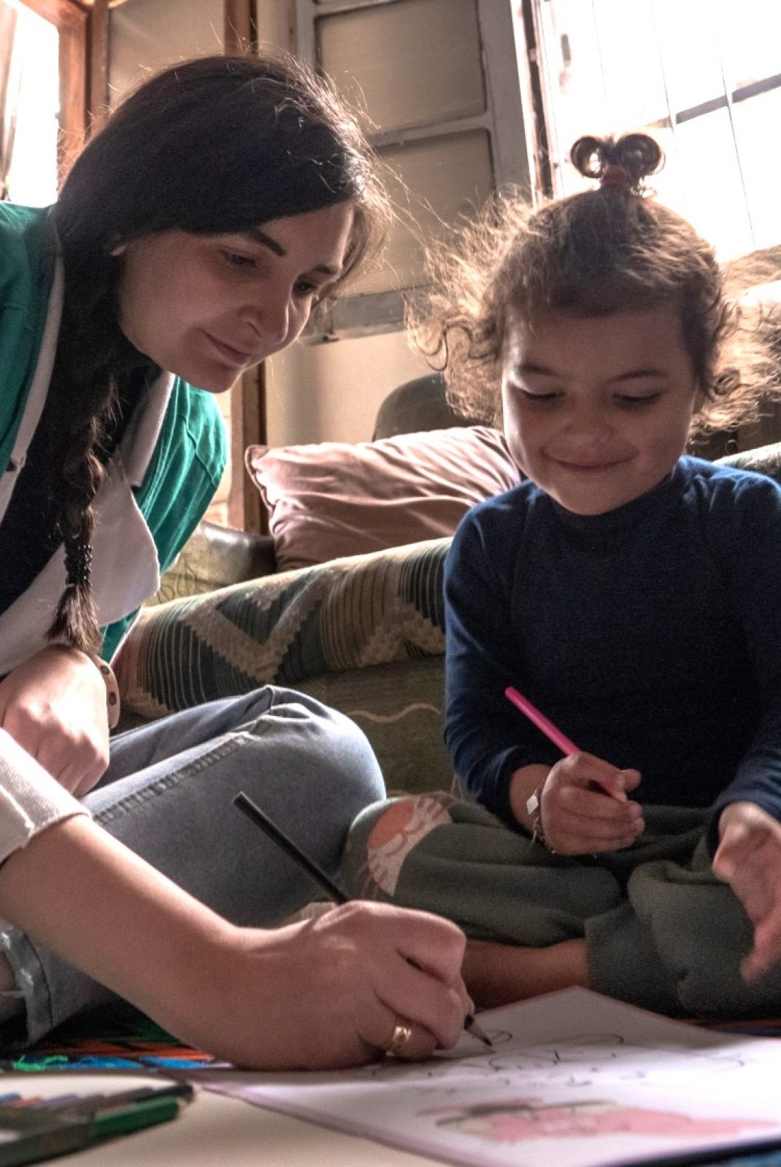 Immagine di una dipendente della Fondazione AVSI che gioca con una bambina 
