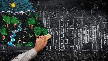 Immagine di una lavagna con illustrazioni di una città e un bosco 