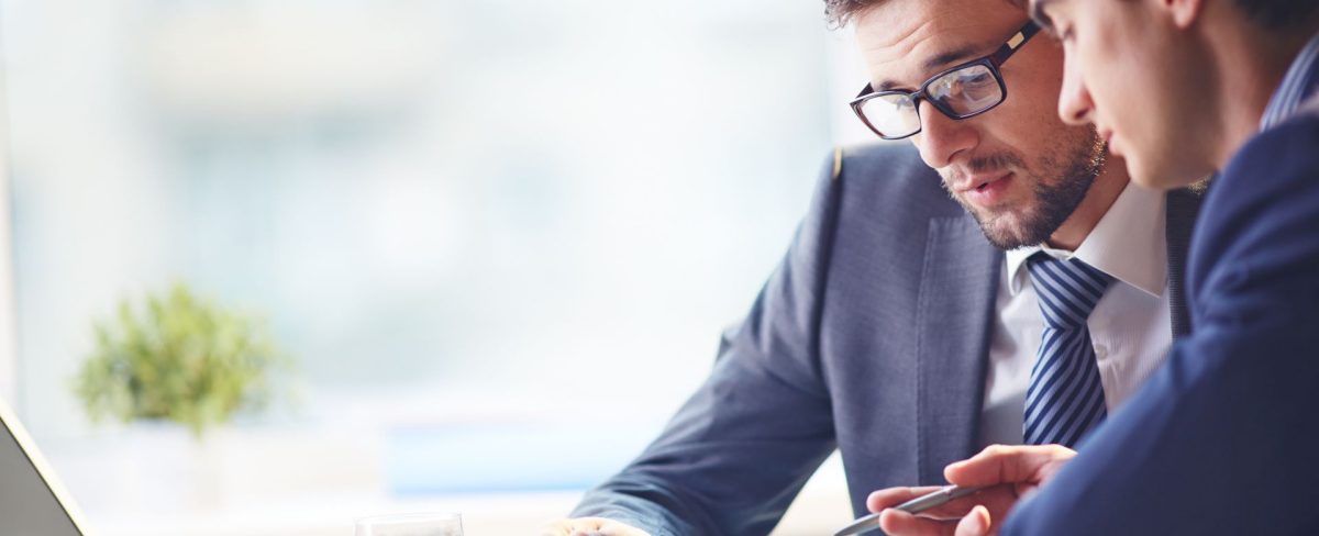 L’immagine che accompagna la News sull’investimento di Neva SGR in BetaGlue Technologies e Casavo, ritrae due uomini in giacca e cravatta, seduti uno a fianco dell'altro, e intenti a consultare insieme un tablet su una scrivania in cui si intravedono anche un pc portatile e un bicchiere d'acqua