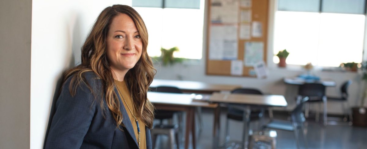 The image accompanying the News on the resources of the Charity Fund headed by the Presidency which in 2024 have risen to €23.4 million and can be disbursed to Third Sector entities, portrays a smiling young woman with long brown hair, leaning on the entrance to a room in which tables and chairs can be glimpsed