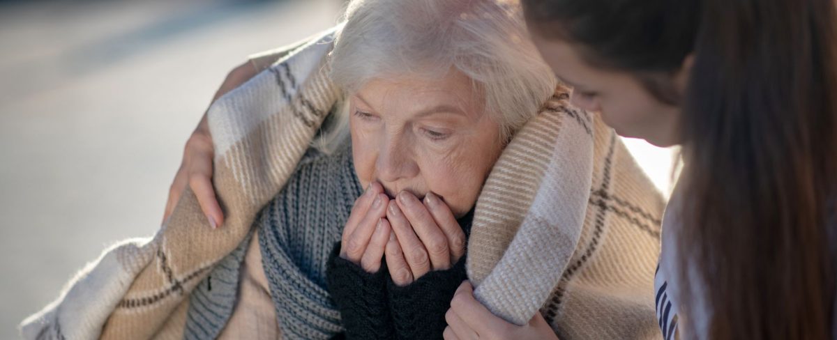 The image accompanying the News on the interventions carried out by Intesa Sanpaolo in 2024 to combat poverty and inequality, portrays an elderly and cold woman and a young woman who hugs her and wraps her in a blanket