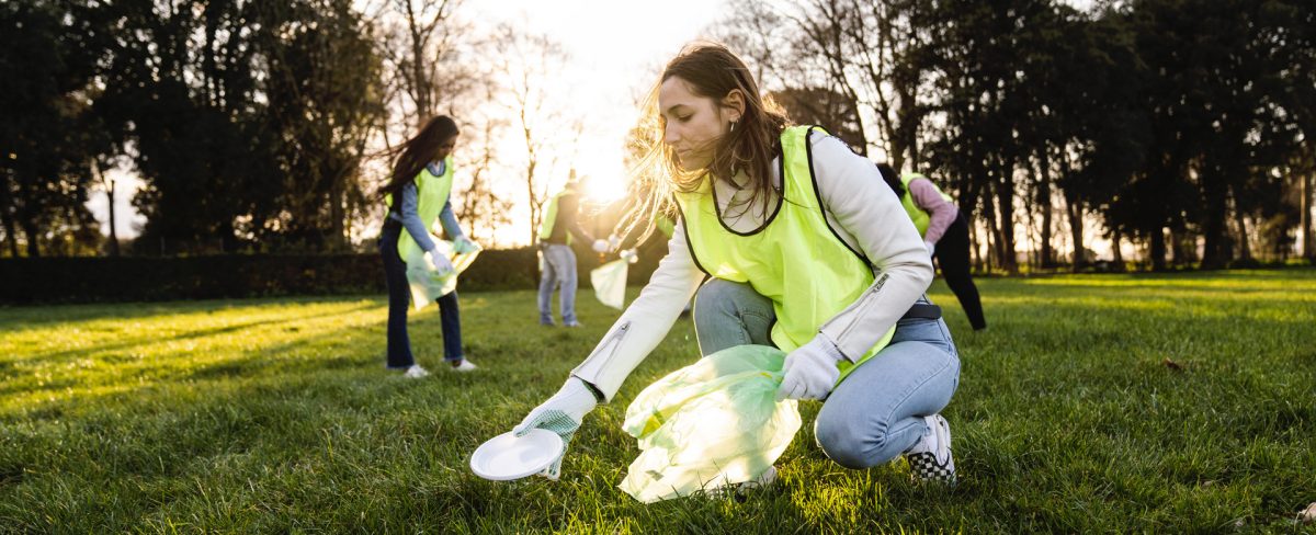 in primo piano ragazza che raccoglie rifiuti abbandonati in un parco